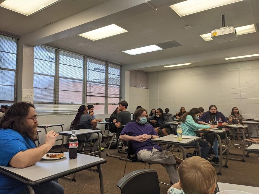 several students sitting around attempting to code on paper